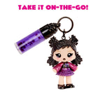 Toy keychain with a small doll and lip gloss on a white background with text 'Take it on-the-go!'.