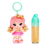 Toy figure with pink hair and gingerbread-themed accessories next to a small bottle on a white background