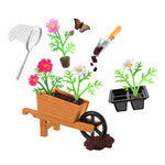 Mini gardening set with wheelbarrow, plants, and tools on a white background