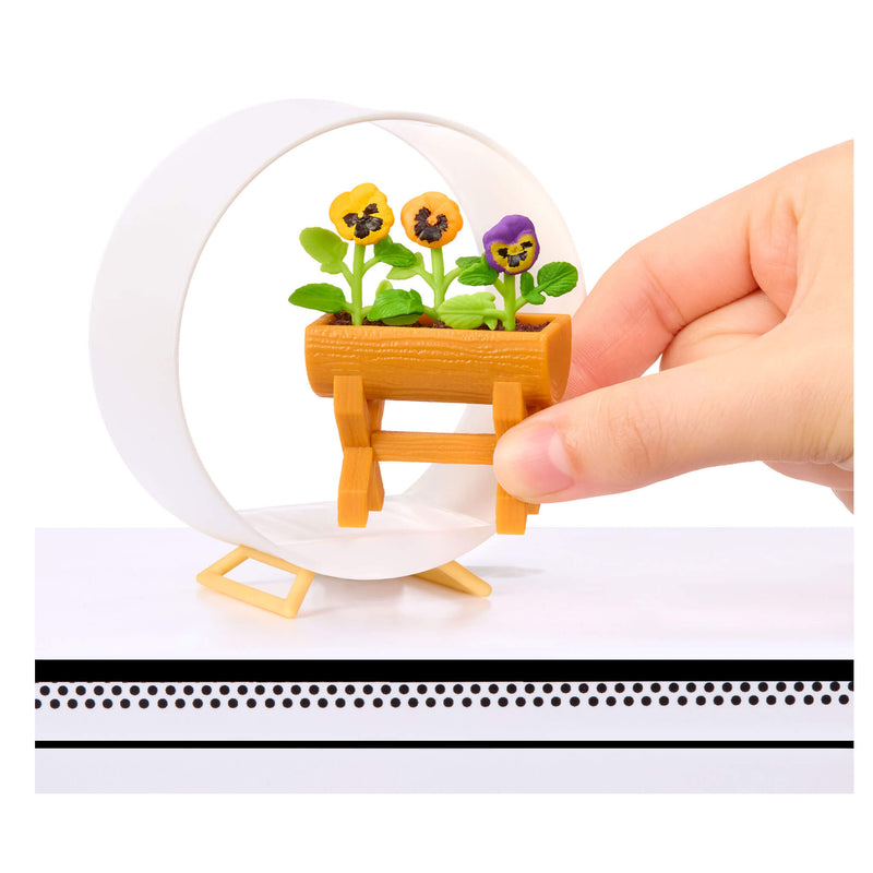 Hand holding a mini decorative pot with flowers on a white background