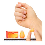 Hand holding a small orange bottle with a box labeled 'Fruity' on a white background
