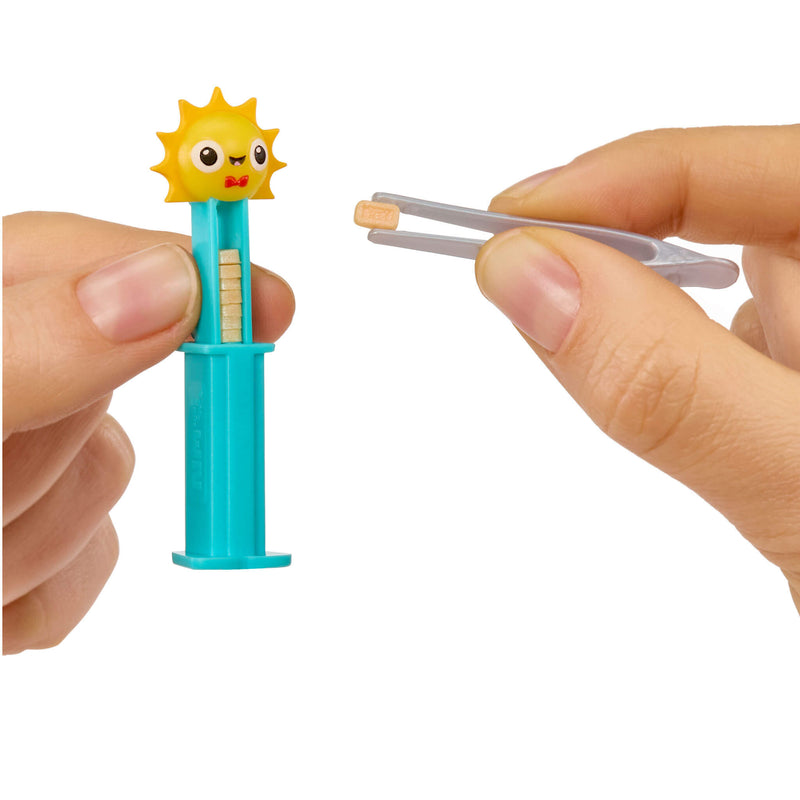 Small sun Pez with a blue handle held by a hand against a white background