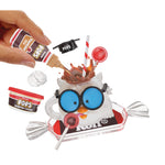 Mini owl, surrounded by Pops whipped cream, chocolate, and other accessories on a white background.