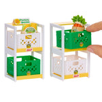 Toy produce stand with green and white crates and mini vegetables on a white background