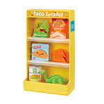 Yellow toy taco stand with various taco-themed items on a white background