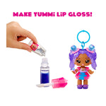 Toy doll with purple hair and colorful outfit next to lip gloss and applicator, with text 'MAKE YUMMI LIP GLOSS!'.