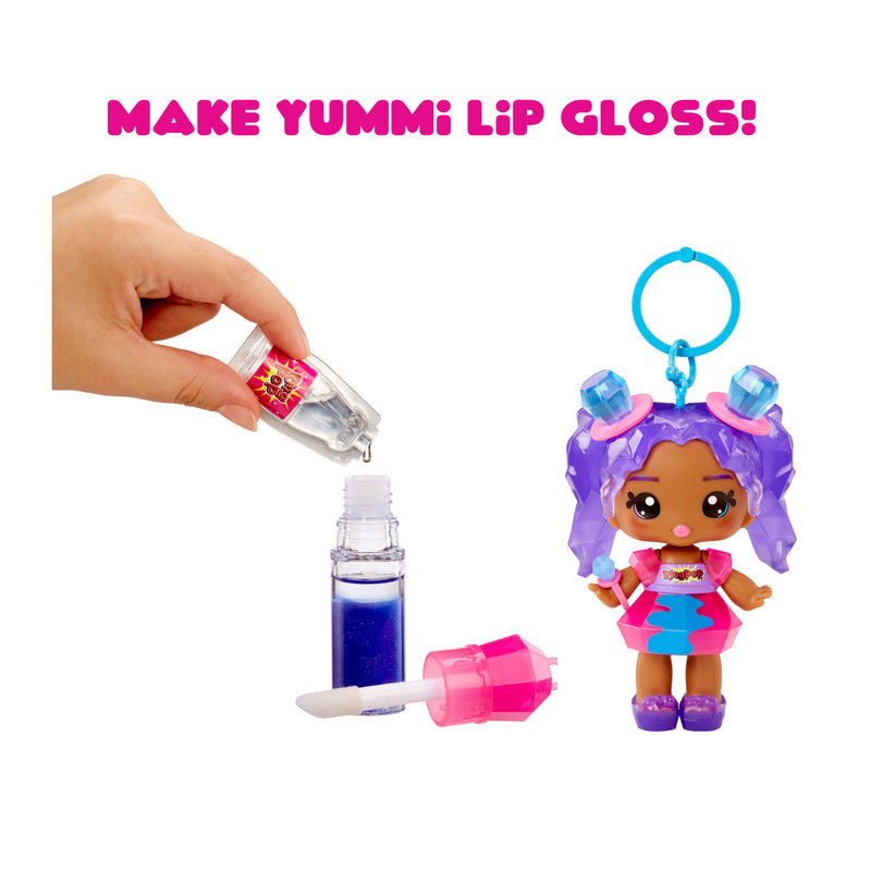 Toy doll with purple hair and colorful outfit next to lip gloss and applicator, with text 'MAKE YUMMI LIP GLOSS!'.
