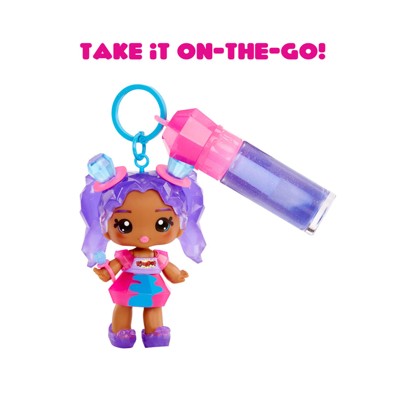 Small doll with purple hair and a pink outfit holding a colorful bottle, with 'Take It On-The-Go!' text above.