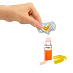Hand adding scent to bottle of orange liquid on a white background