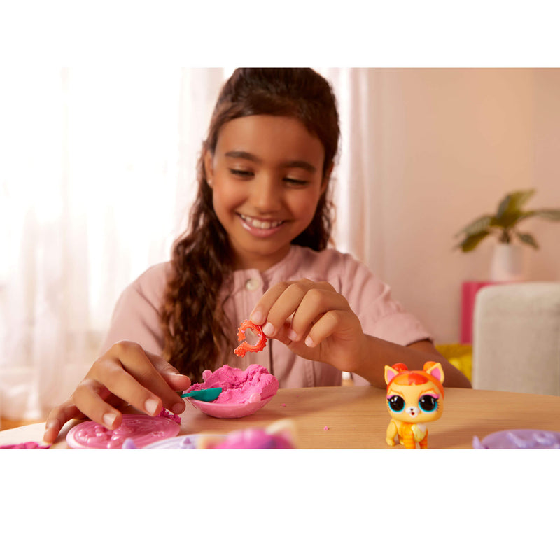 Child playing with a toy pet object at a table.