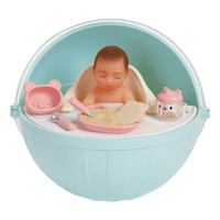 Fair skin baby in a blue capsule with accessories on a white background