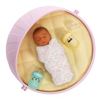 Darker skinned baby in a pink crib with a bottle and yellow toy