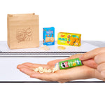 Hand holding a tube of Pringles with snacks in the background