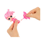 Small pink toy figure with a hand removing very bottom of tail to show lip brush on a white background