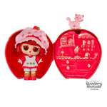 Strawberry Shortcake doll by a strawberry shaped case with a kitty on top, on a white background.