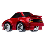 Red toy car with chrome wheels on a white background