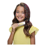 Girl with colorful hair accessories holding a hair product against a white background