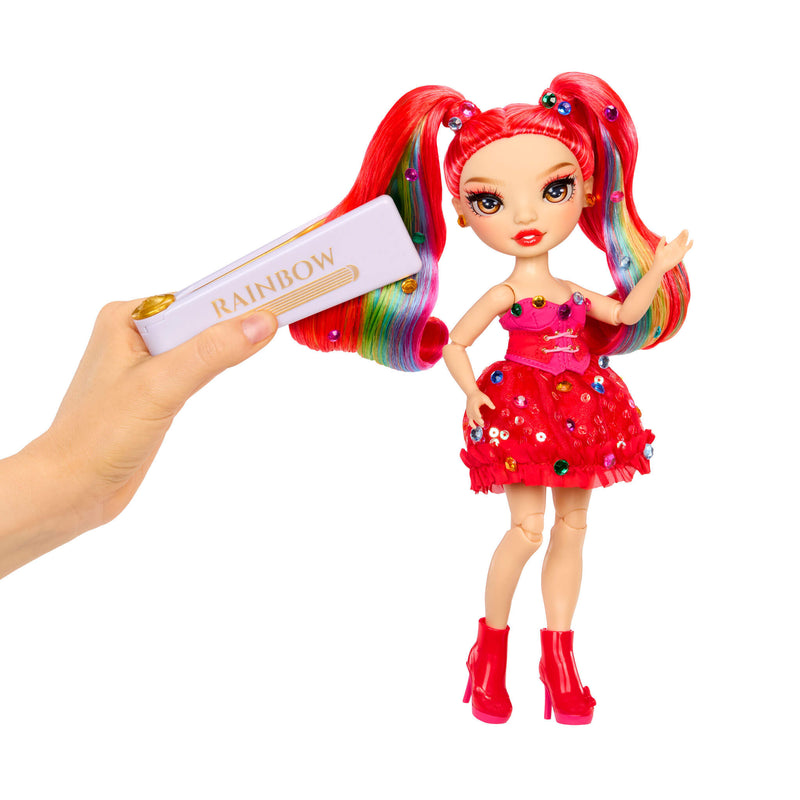 Toy doll with red hair and dress, holding a bedazzling tool with 'Rainbow' text on a white background