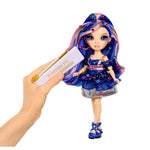 Doll with colorful hair and outfit, next to a Hand holding a bedazzling tool with 'Rainbow' text on a white background