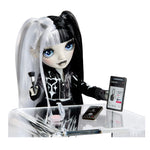 Doll with black hair and white ponytail, sitting at a table with electronic devices.
