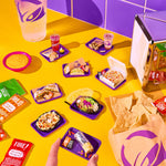 Colorful table with Taco Bell food items including burritos, nachos, and drinks on a vibrant yellow and purple background.