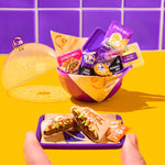 Taco Bell food items and packaging on a purple tray with a purple and yellow container in the background.
