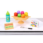 Miniature, colorful Pretty Patties and sauce on a white surface with a black border