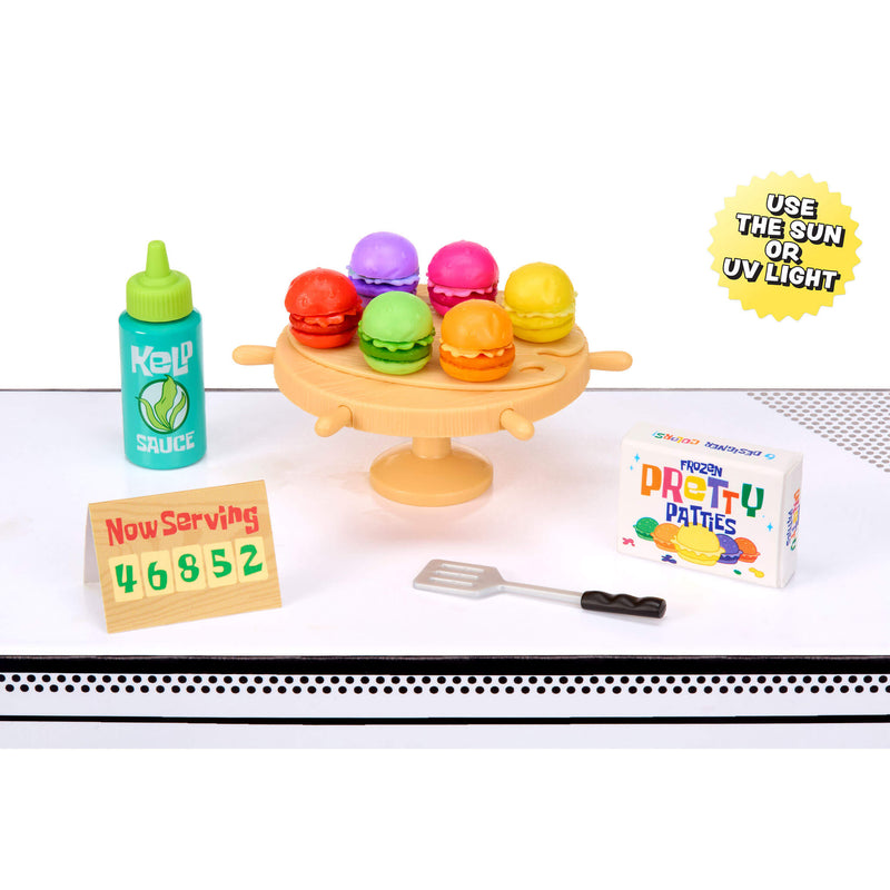 Miniature food items and accessories on a white surface with text and branding.