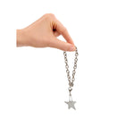 Hand holding a silver bracelet with a star pendant on a white background