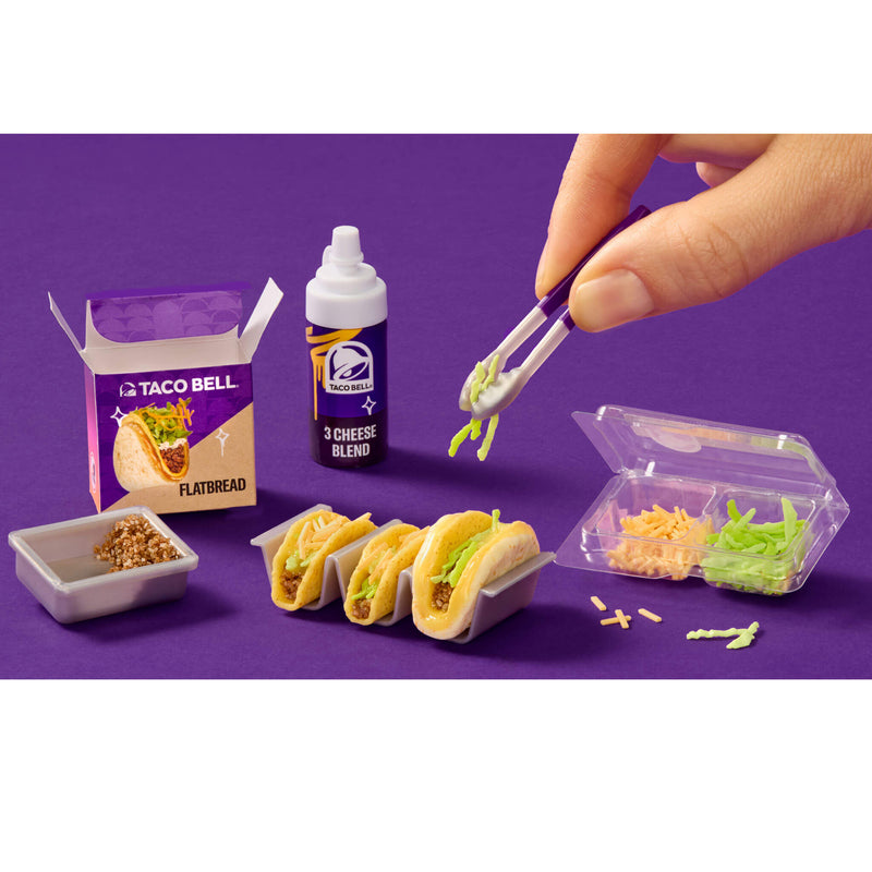Miniature Taco Bell food set with hand adding toppings on a purple background