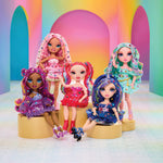 Five colorful dolls with vibrant hairstyles and outfits against a rainbow-colored archway.