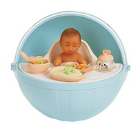 Toy baby in a high chair in blue capsule with food and a blue chair on a white background