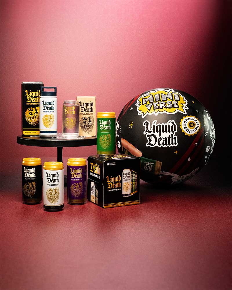 Collection of 'Liquid Death' Miniverse products including bottles and a helmet on a red background