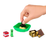 Hand interacting with a Minecraft-themed toy set on a white background
