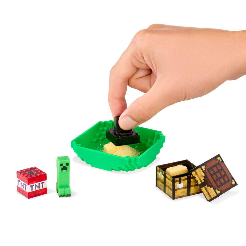 Hand interacting with a Minecraft-themed toy set on a white background