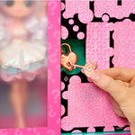 Pink heart-shaped keychain with a hand interacting with it against a pink and black patterned background.
